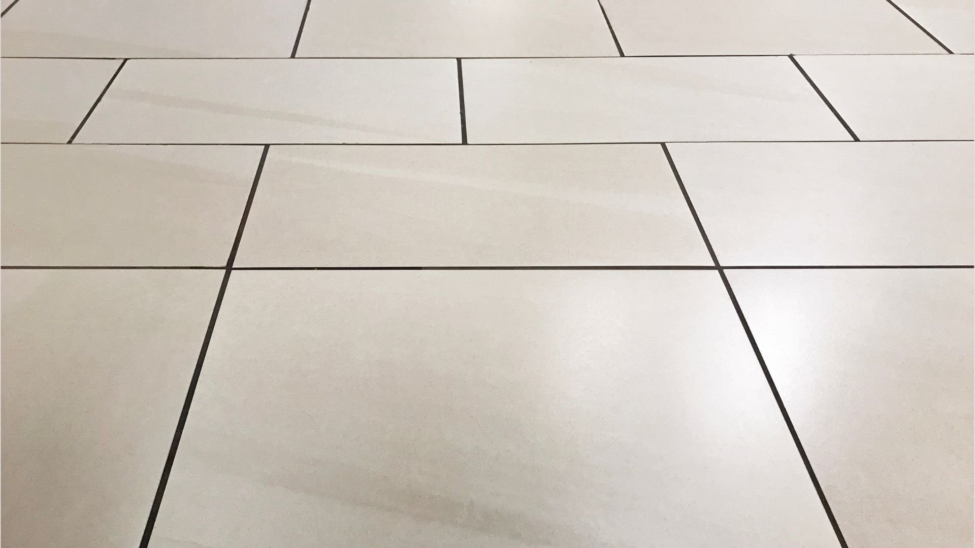 Clean white ceramic tiles with dark grout lines in geometric pattern
