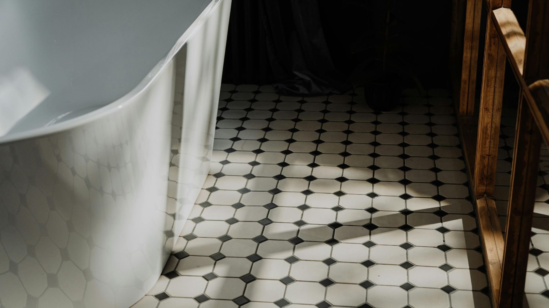 White bathtub on black and white octagonal mosaic tile floor