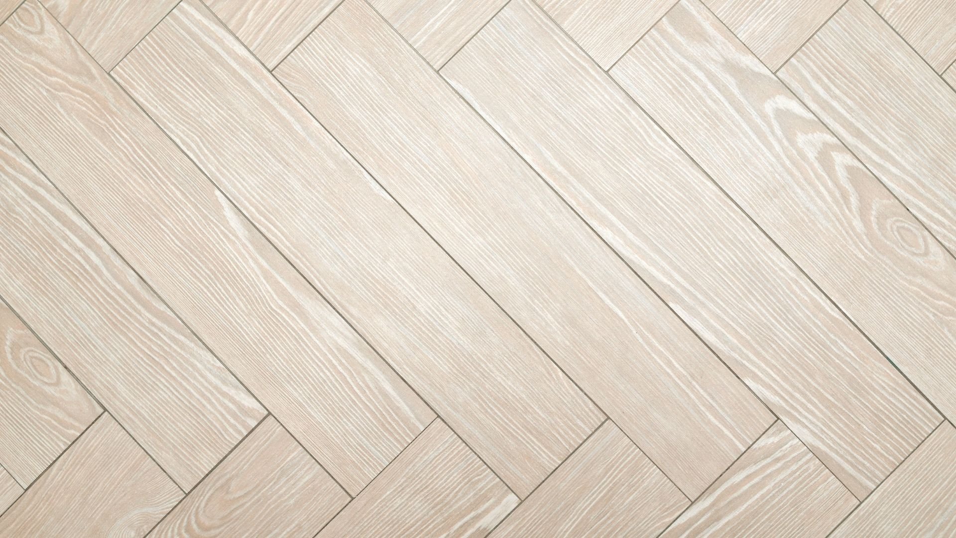 Light wood herringbone parquet flooring with diagonal wooden planks