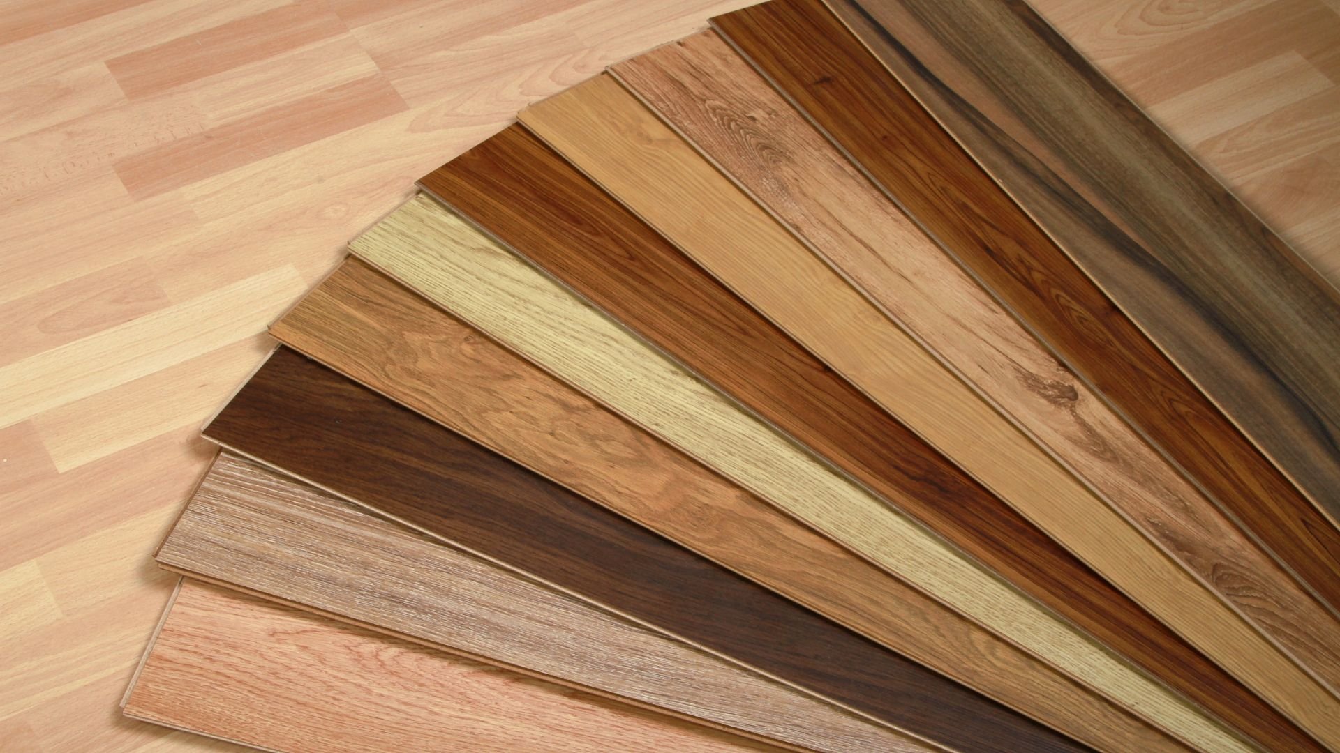 Variety of wooden laminate or vinyl flooring samples in different colors